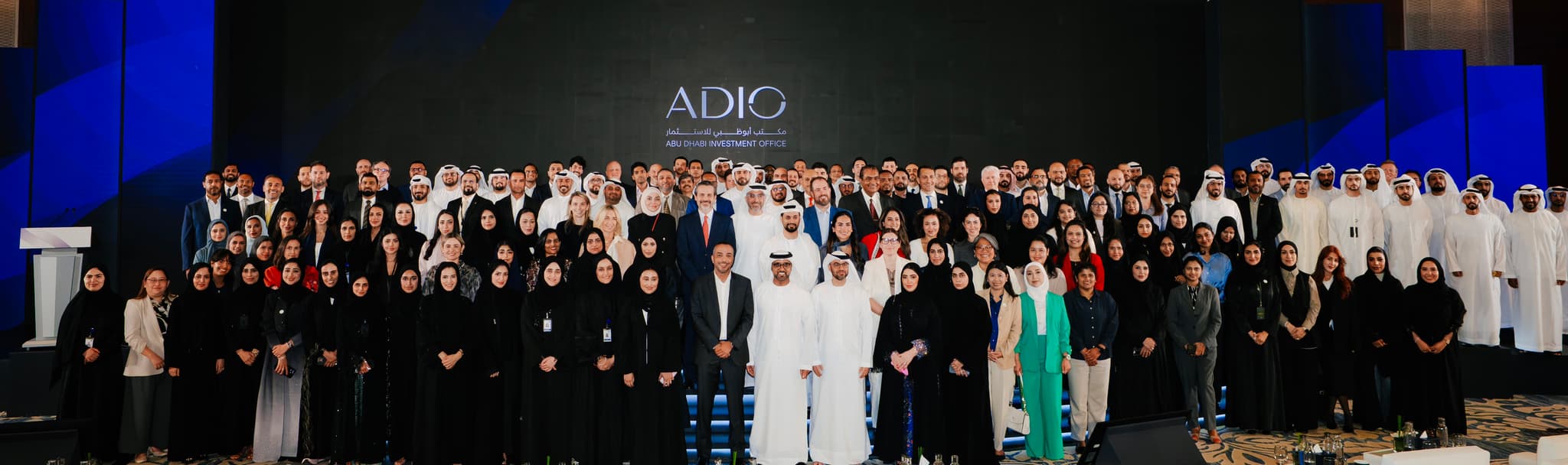 فريق ADIO على المنصة أسفل شعار ADIO النصي